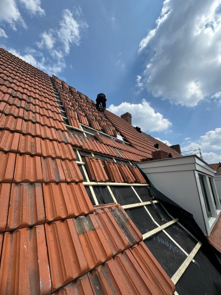 Kapotte dakpannen repareren op een rijtjeshuis door Dakdek Gigant